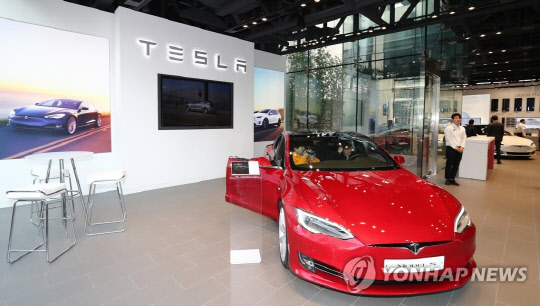 2017년  3월 서울 강남구 청담동에 개장한 미국 전기차업체 테슬라 국내 2호 매장에서 방문객들이 전시차량을 살펴보고 있다. 연합뉴스